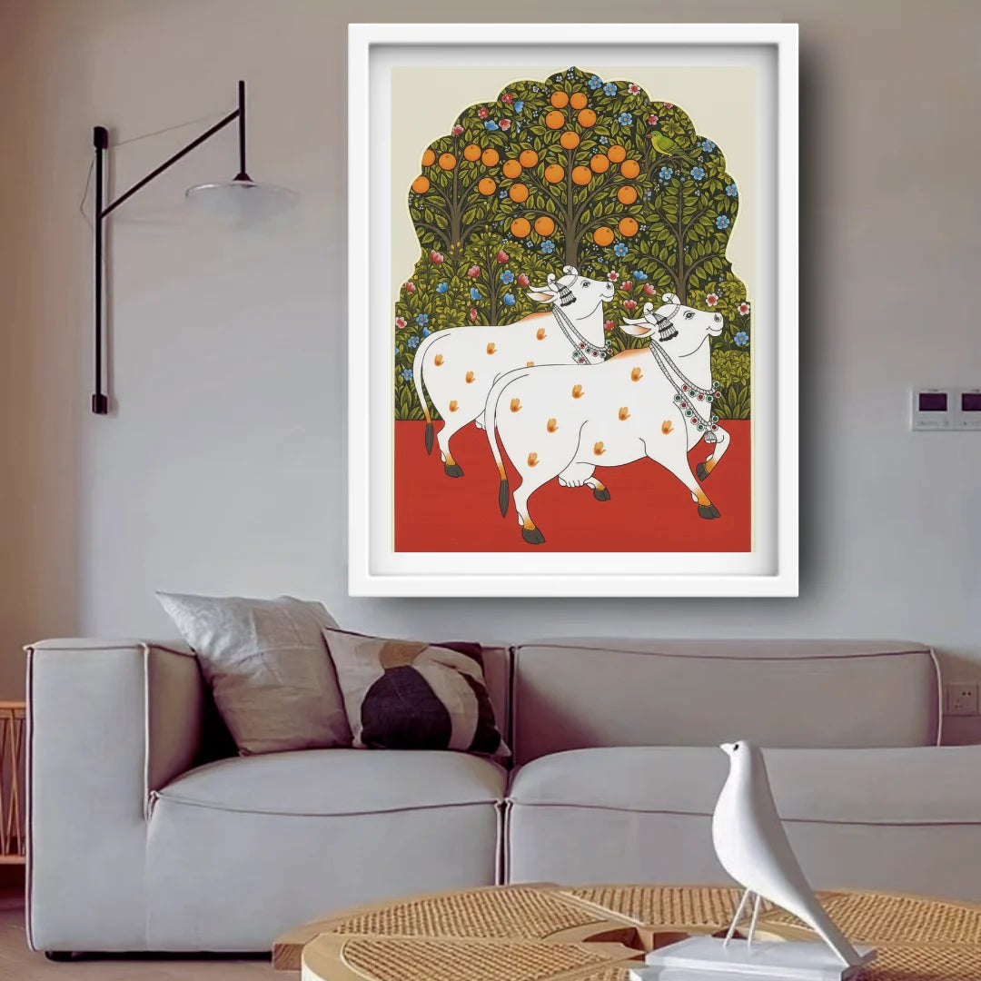Framed artwork of two cows under an orange tree in a living room.