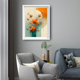 A framed abstract floral art print with orange flowers and teal geometric shapes hangs on a gray wall above a modern gray armchair in a styled living room.