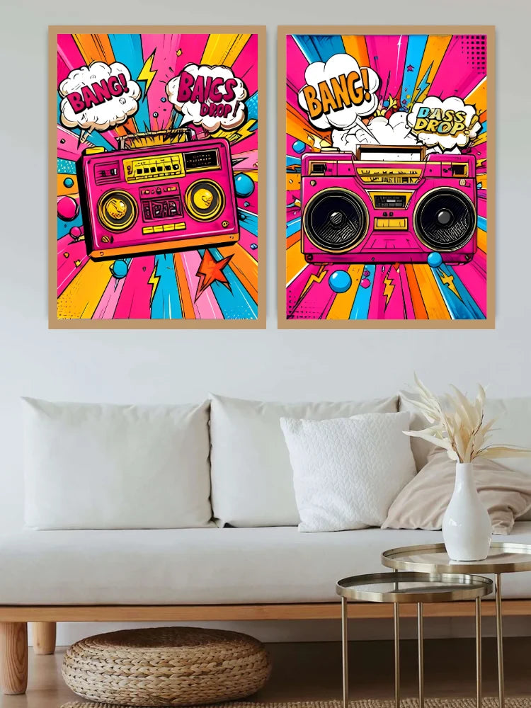 A pair of framed pop-art posters featuring retro boomboxes and comic-style text, displayed above a white sofa in a modern living room setting.