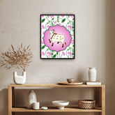 Framed artwork of a cow with flowers on a wall above a wooden shelf with decorative items.