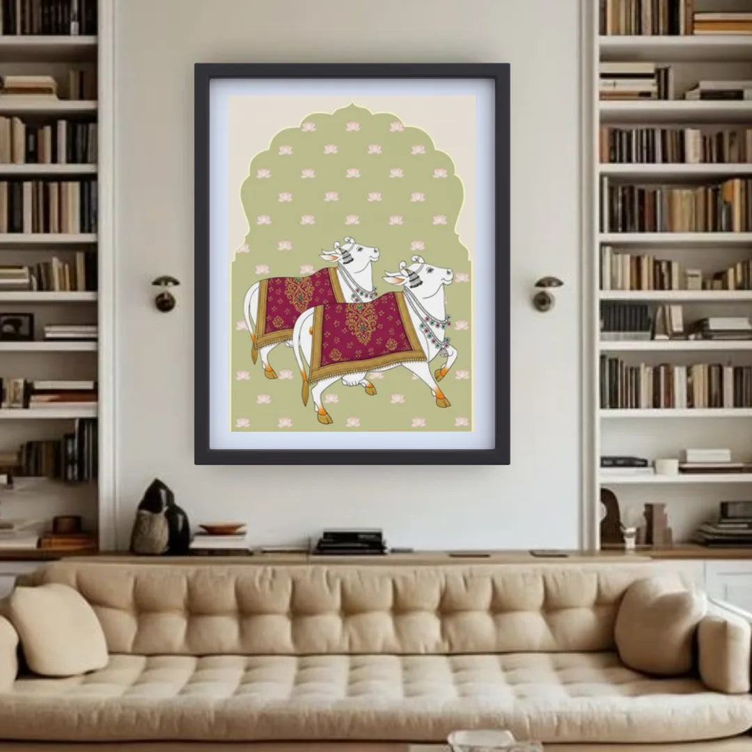Framed artwork of two cows on a green background in a living room with bookshelves.