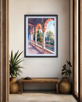 A framed art print depicting a vibrant Moroccan-style archway corridor with lush greenery and a blue sky, displayed on a beige wall above a wooden bench with potted plants.