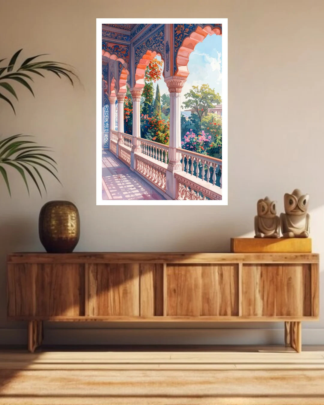 A framed art print depicting a colorful traditional archway balcony with lush greenery and pink flowers, displayed on a beige wall above a wooden console table in a styled room.