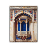 A vertical rectangular wall art print depicting an ornate architectural balcony or pavilion with cream stone detailing, blue draped interior panels, and colorful floral motifs around the arches, shown against a plain white background.