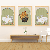 Three framed artworks on a wall above a wooden console table with a chair.