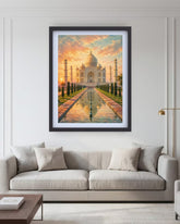 A framed art print of the Taj Mahal at sunset, displayed on a white wall above a modern light gray sofa in a styled living room setting.