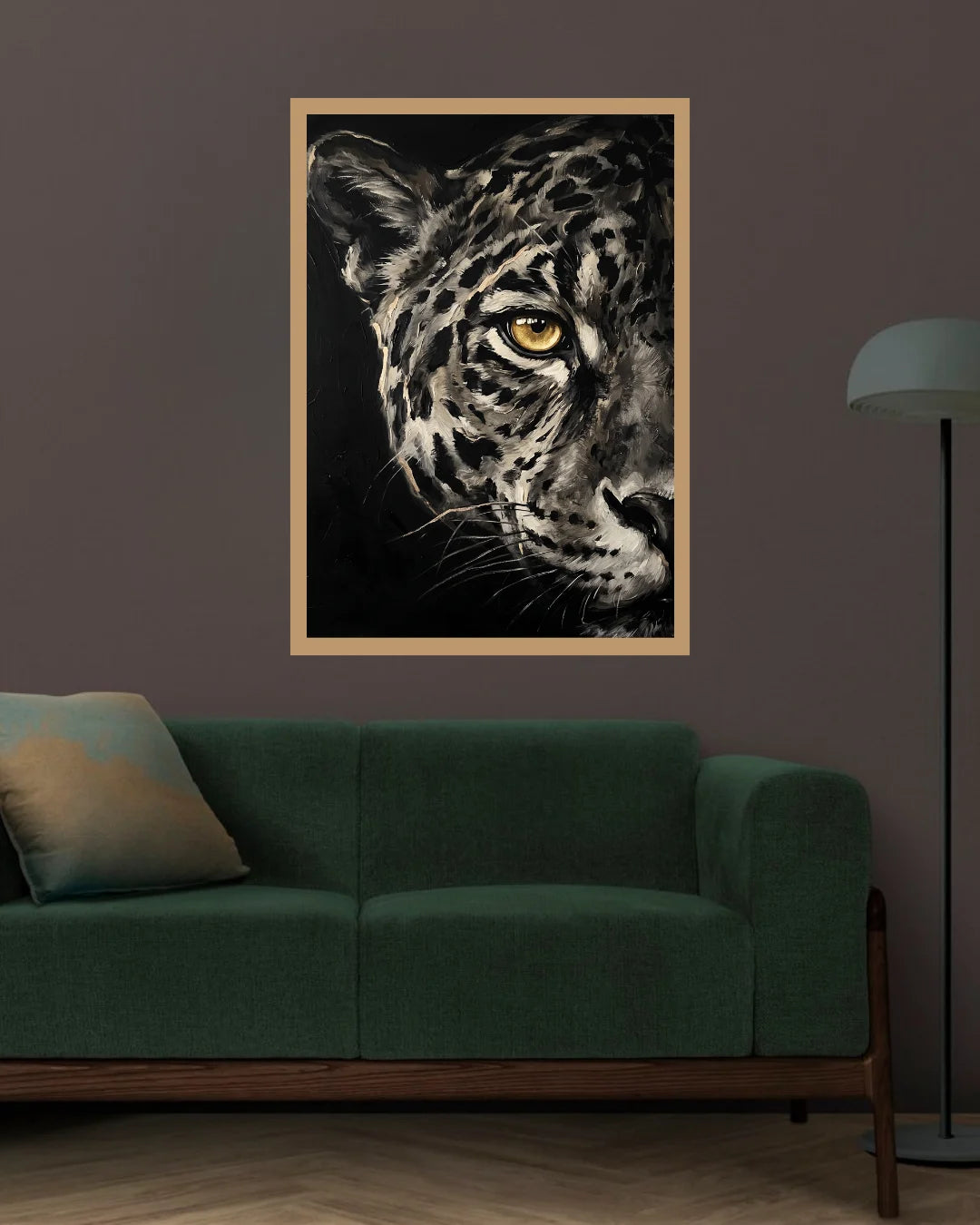 A framed black and white leopard art print with a striking yellow eye hangs on a dark gray wall above a green sofa in a modern living room setting.