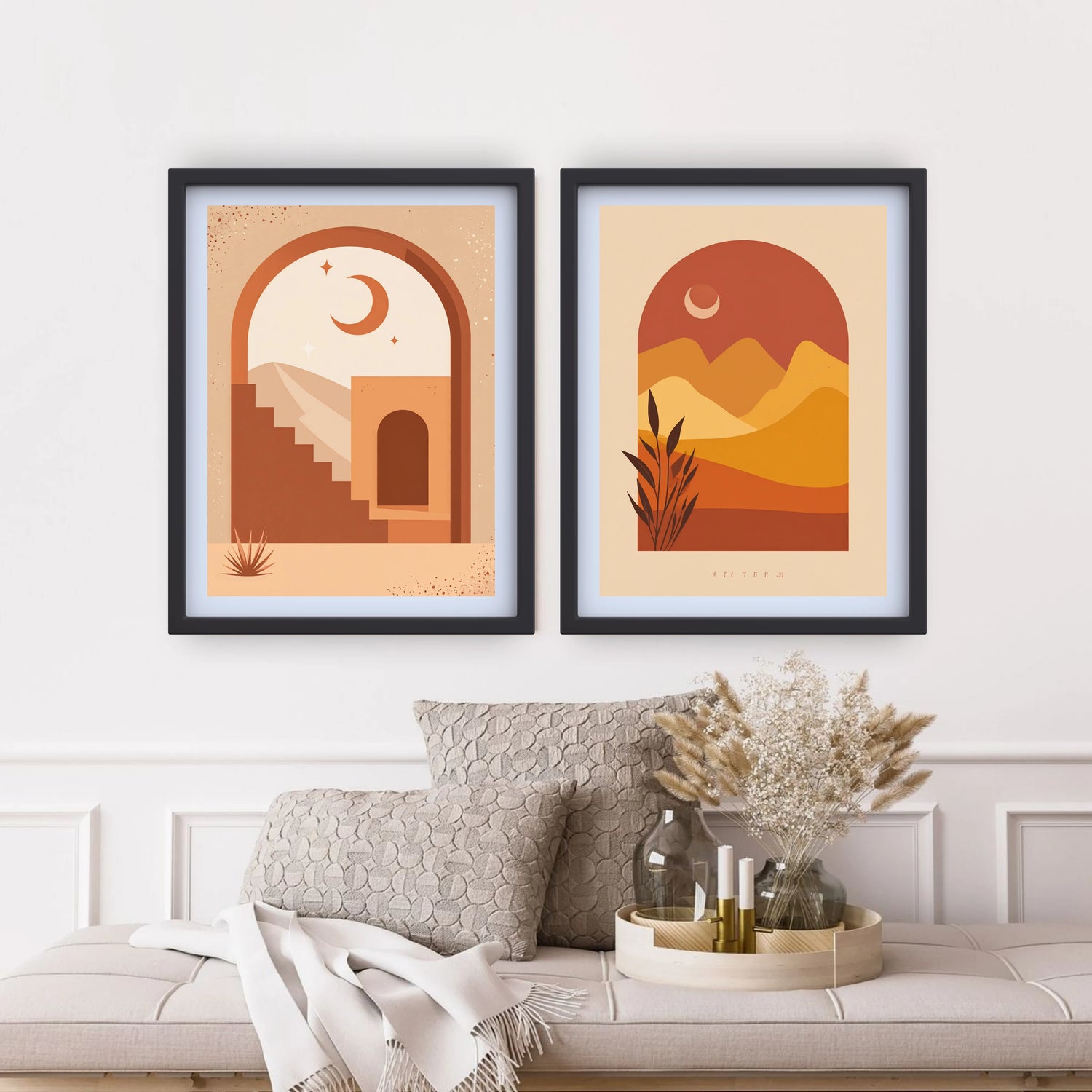 Two framed artworks of desert landscapes on a wall above a sofa.
