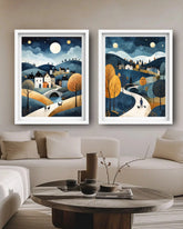 Two framed landscape paintings above a sofa in a living room.