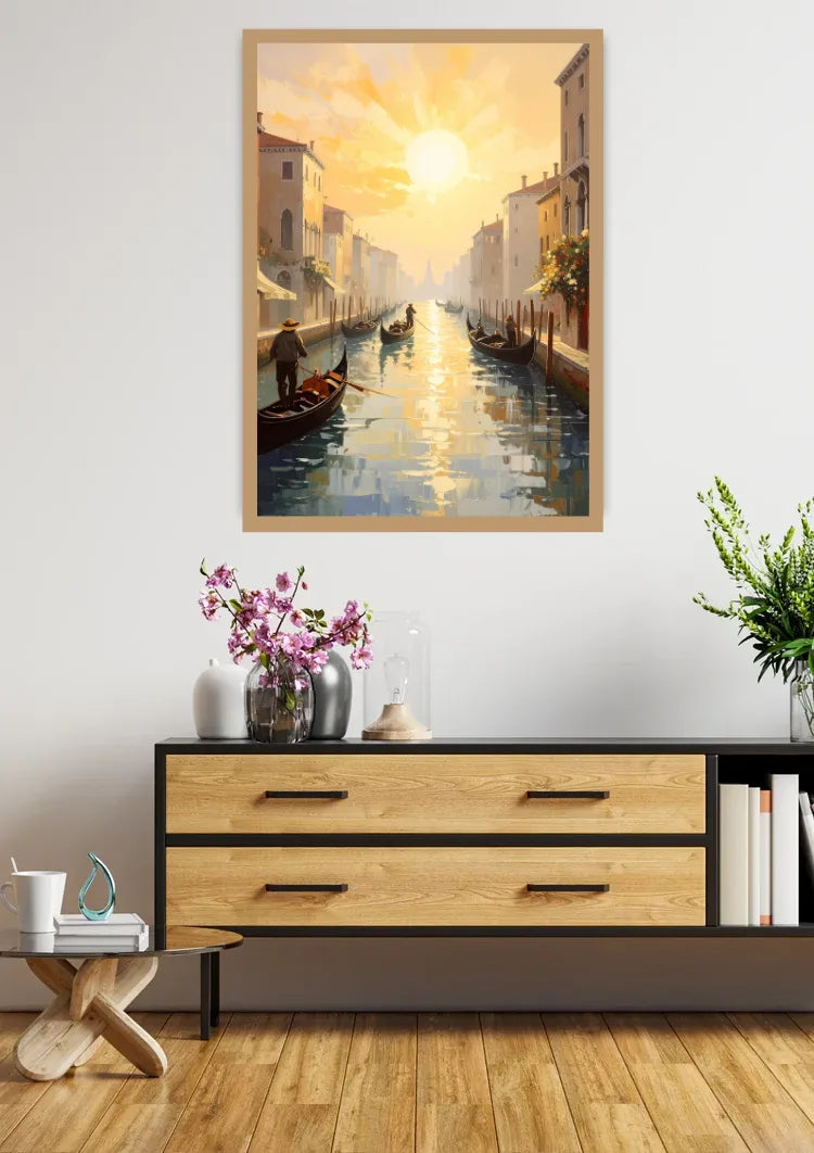 A framed vertical canvas print of a Venice canal sunset hangs on a white wall above a modern wooden console table with decorative items.