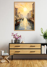 A framed vertical canvas print of a Venice canal sunset hangs on a white wall above a modern wooden console table with decorative items.