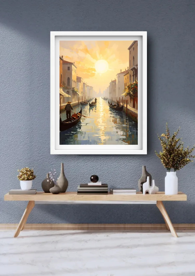 A framed art print depicting a Venice canal sunset hangs on a textured gray wall above a light wood console table with decorative vases and plants.