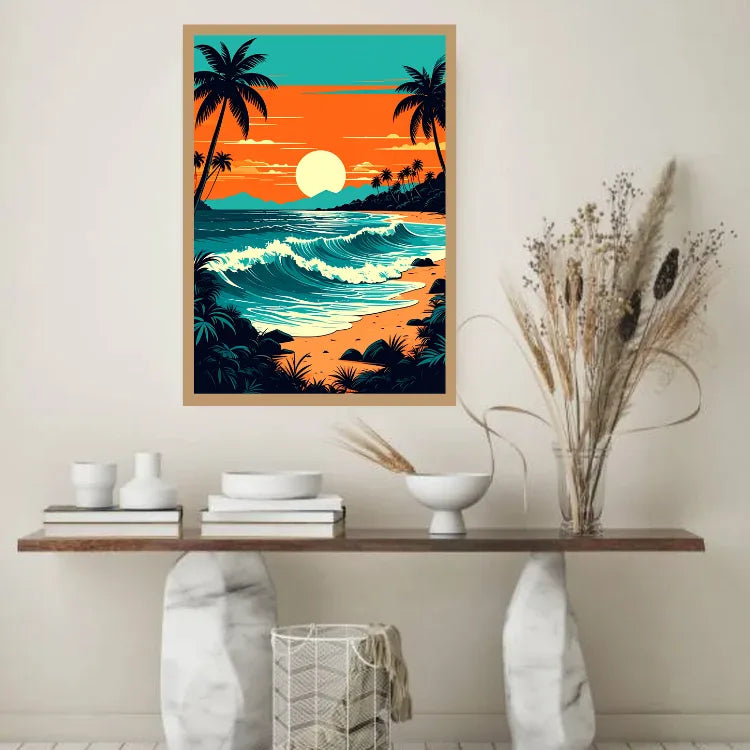 A framed vertical art print depicting a tropical beach sunset hangs on a beige wall above a console table styled with books, white ceramic vases, and a glass vase of dried grass.