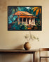 A framed art print depicting a tropical house surrounded by lush green foliage and orange palm leaves, hanging on a beige wall above a rustic wooden table with a ceramic pot.