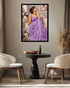 A framed art print depicting a woman in a flowing lavender gown holding a glass of red wine, displayed on a neutral wall above a modern black round table and two cream-colored chairs.