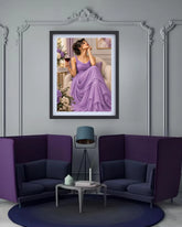 A framed art print of a woman in a lavender gown hanging on a gray wall above a modern purple and navy lounge set with a small side table and lamp.