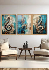 A set of three framed canvas wall art prints featuring large musical treble clefs over blue and beige abstract backgrounds, displayed in a modern living room setting above two armchairs and a small round table.