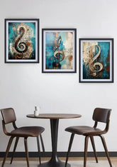 Three framed abstract wall art prints featuring musical treble clefs in teal, beige, and brown tones, displayed on a white wall above a small round table and two brown chairs.