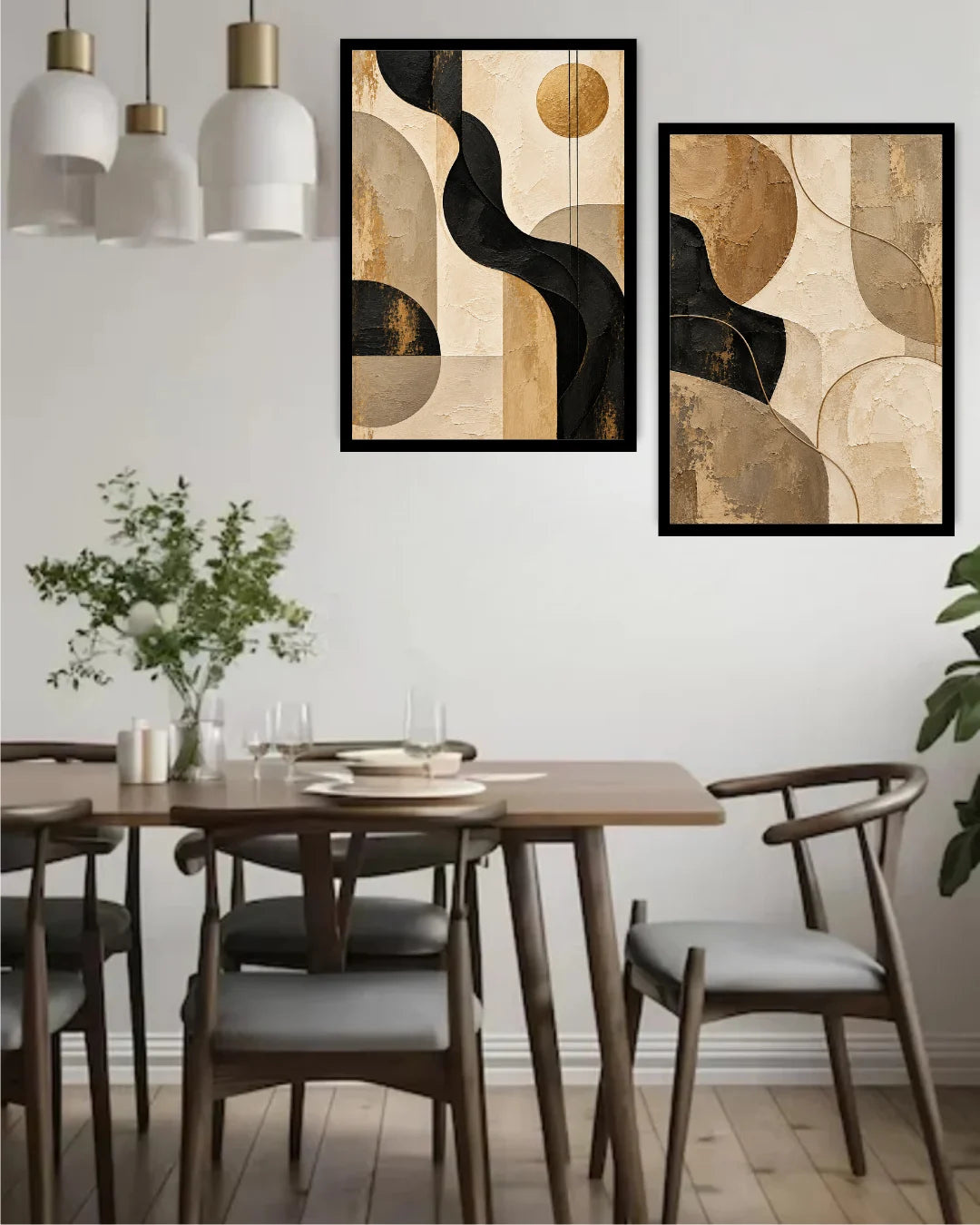 Two framed abstract wall art prints with black, beige, and gold geometric shapes hanging above a wooden dining table with chairs in a modern dining room.