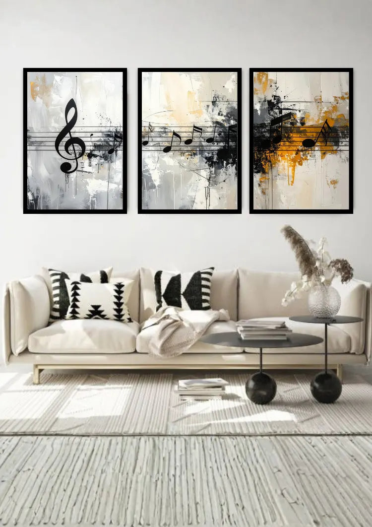 A three-piece framed wall art set featuring abstract black, white, and gold musical notes and staff lines, displayed above a modern beige sofa in a styled living room.