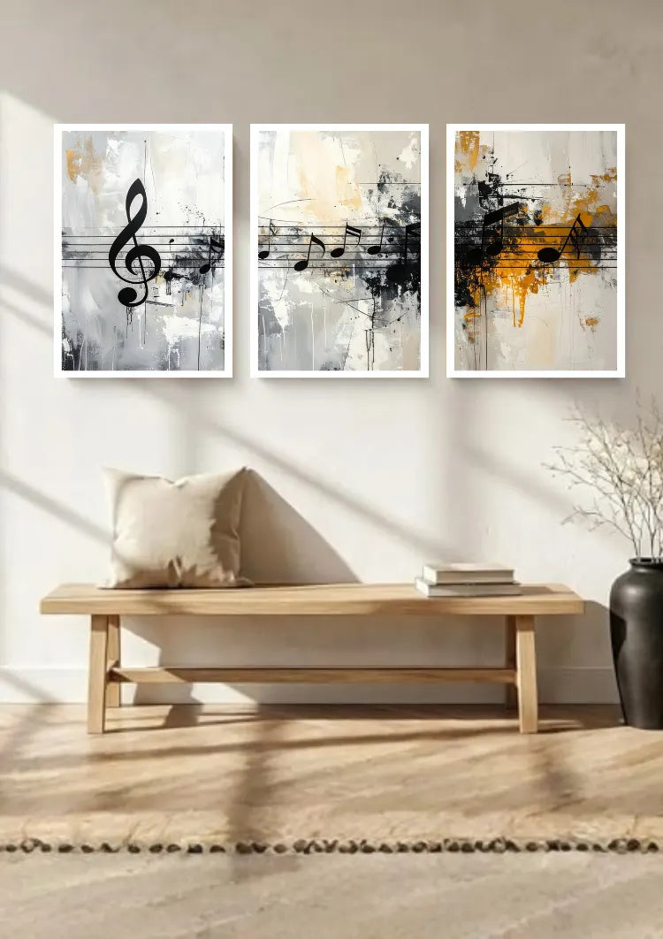 Three framed abstract wall art prints with musical notes hang above a light wood bench in a bright, modern room with a beige pillow, books, and a dark vase.