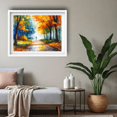 Framed painting of a autumnal landscape on a wall above a sofa.