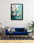Bird and blossom floral wall art canvas displayed above a blue sofa in a modern living room
