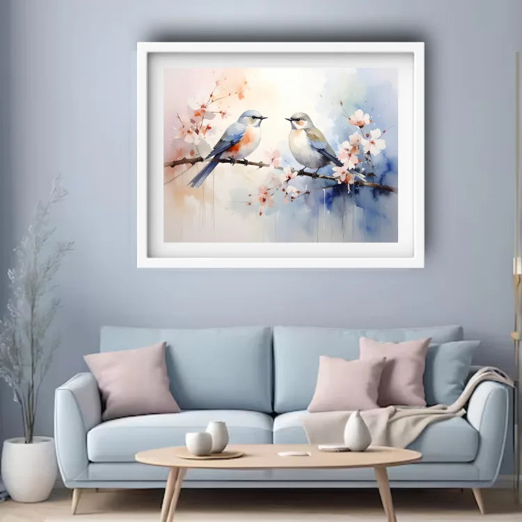 Framed artwork of birds on a branch with flowers above a light blue sofa in a living room.