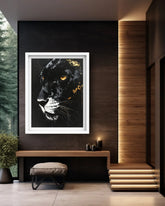 A framed black panther portrait with glowing amber eyes hangs on a dark wall in a modern interior setting with a bench, stool, candles, wood paneling, and steps.
