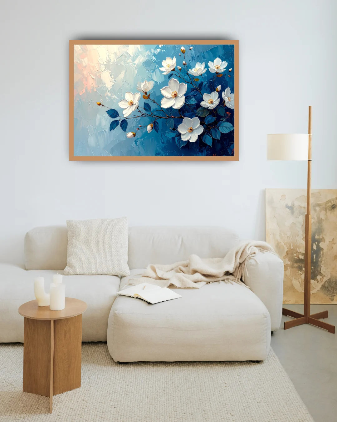 Blue floral wall art canvas displayed above a cream sofa in a modern living room
