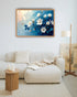 Blue floral wall art canvas displayed above a cream sofa in a modern living room
