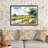 Framed painting of children flying kites in a field above a sofa with patterned cushions.