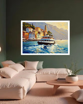 A framed art print depicting a scenic coastal town with colorful buildings, a boat on blue water, and mountains in the background, displayed on a dark green wall above a modern beige sectional sofa in a living room setting.