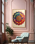 A colorful mandala art print in a gold frame hangs on a pink wall in a styled room with a light blue armchair, a potted plant, and ornate molding.