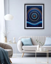 Framed abstract art piece on a wall above a sofa in a living room.