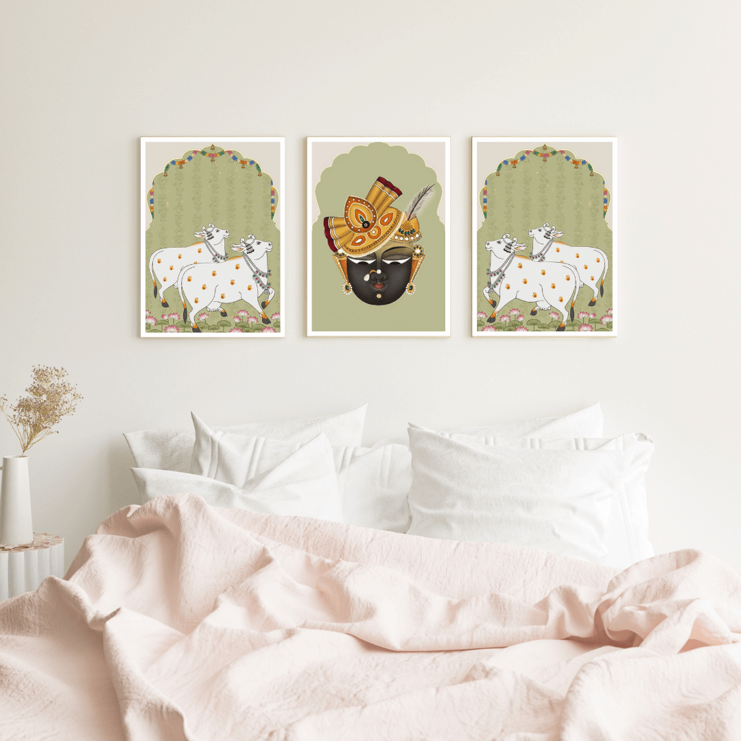 Three framed artworks on a wall above a bed with pink bedding.