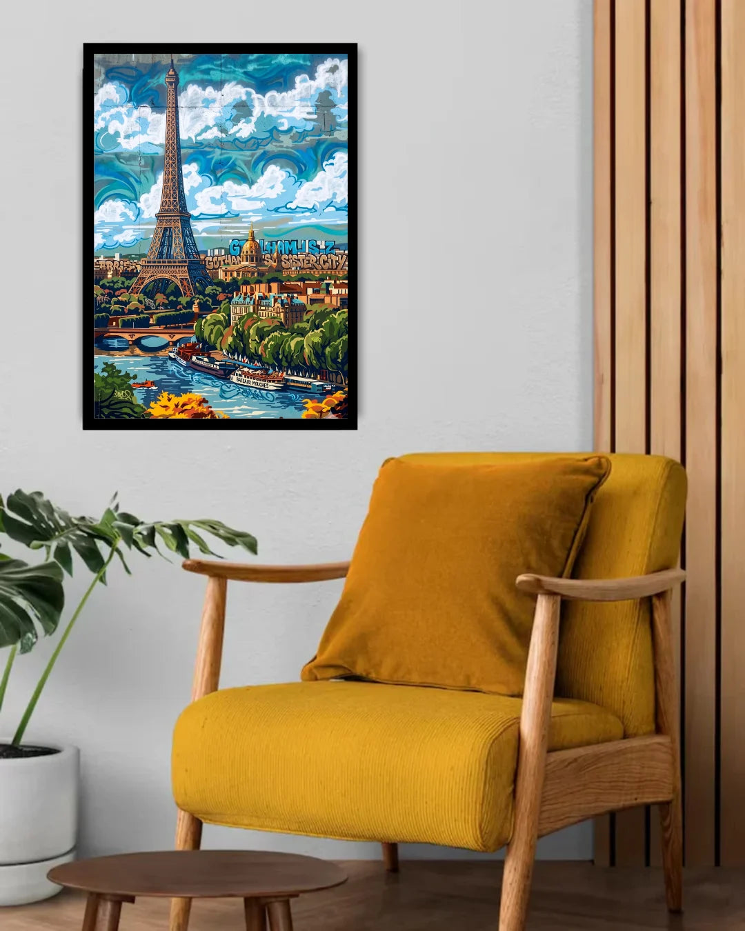 Yellow armchair in a room with a framed artwork of Paris on the wall.