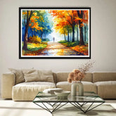 Framed painting of a forest path with autumn colors above a beige sofa in a living room.