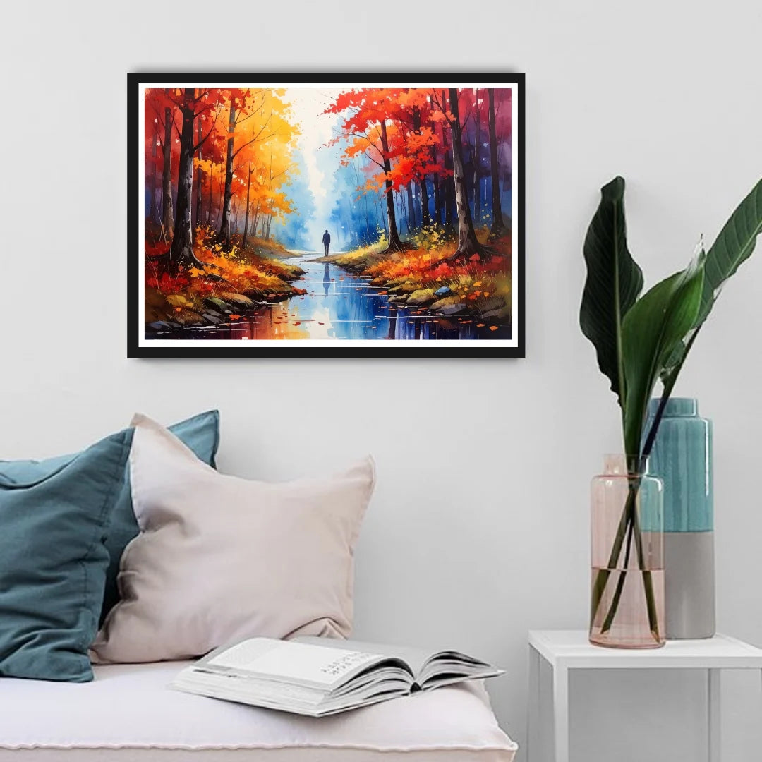 Framed painting of a forest scene above a sofa with pillows and an open book.