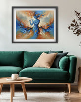 A framed abstract painting featuring a blue figure with orange and beige brushstrokes, displayed on a light gray wall above a green sofa in a modern living room setting.