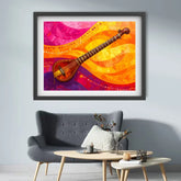 A framed colorful wall art print featuring a stylized stringed instrument over flowing pink, orange, yellow, and purple waves, displayed above a gray armchair in a modern living room setting.