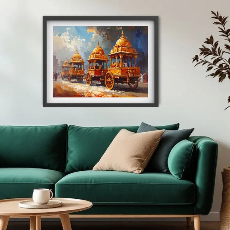 A framed art print depicting three ornate golden chariots under a dramatic blue sky, displayed on a light gray wall above a green sofa with decorative pillows.