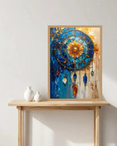A framed abstract dreamcatcher-style wall art print leaning on a light wood console table against a white wall, with two small white vases beside it.