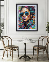 Framed colorful artwork of a woman with sunglasses in a dining room setting.
