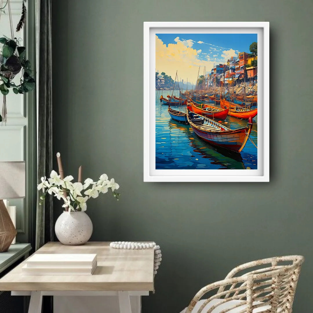 Framed artwork of a harbor scene with boats on a gray wall above a table with a vase and flowers.