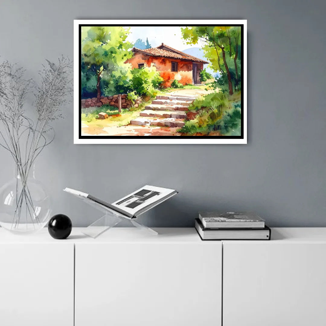 Framed painting of a rustic house in nature on a wall above a white cabinet.