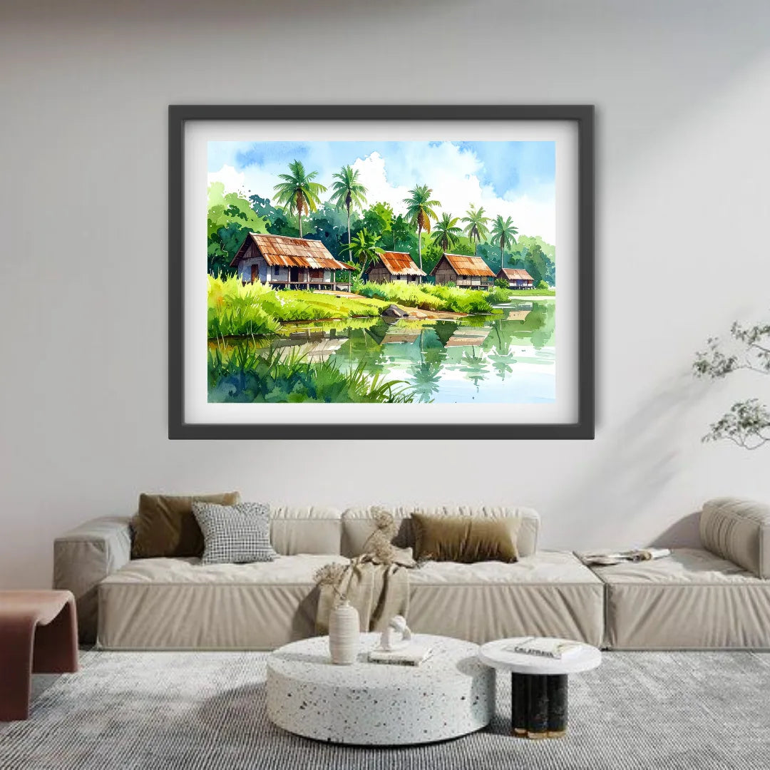 Framed landscape painting of a tropical scene with houses and trees on a wall above a sofa.