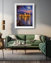 A framed art print depicting a scenic lake house at sunset is displayed on a gray wall above a green sectional sofa in a modern living room setting.