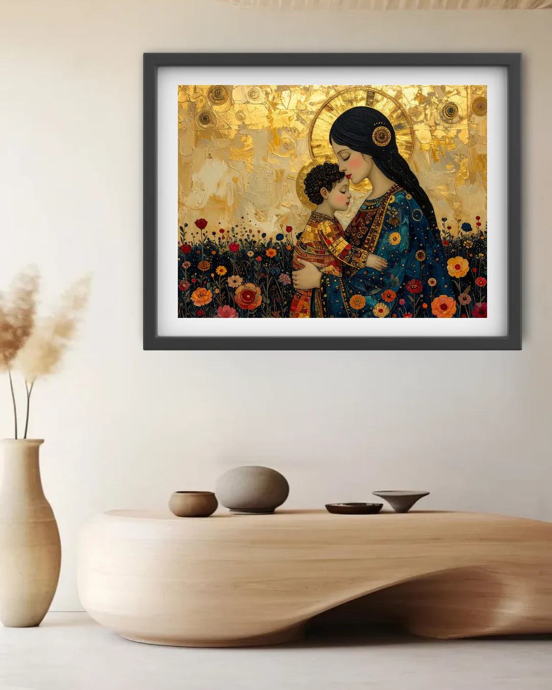 A framed art print depicting a mother and child in a golden field, styled on a wall above a wooden console table with neutral decor.