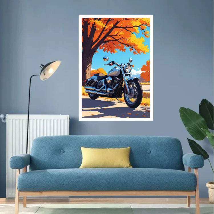 A framed wall art print featuring a blue motorcycle under orange autumn trees, displayed above a blue sofa in a modern living room setting.